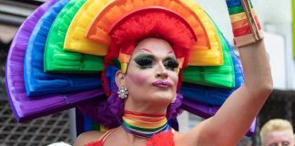 Drag Queen Opener Ignites Portland Schools Firestorm Drag performer in vibrant rainbow costume at a parade