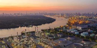 Industrial oil refinery complex beside a river at dusk