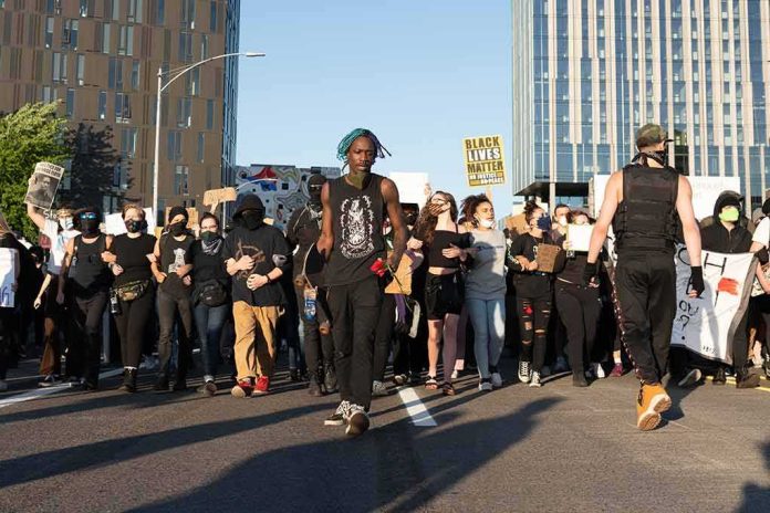 shutterstock_1749272363 Protesters march on a city street holding signs