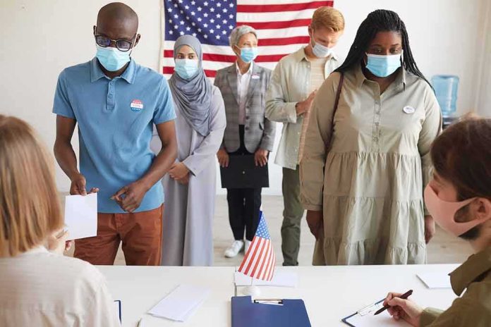 shutterstock_1810359334 Voters wearing masks stand in line at a polling station