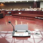 Contempt Clash: Fauci’s Fifth Lights a Fuse Conference microphone on a podium in a courtroom