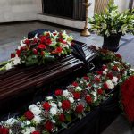 Funeral Home Heist Hits $2.2M Coffin with floral arrangements at a funeral service