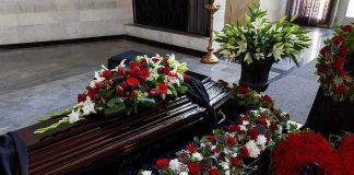 Coffin with floral arrangements at a funeral service