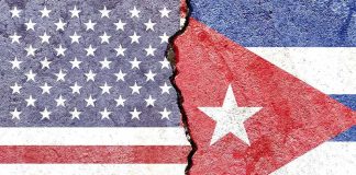 Split wall showing USA and Cuba flags divided by a crack