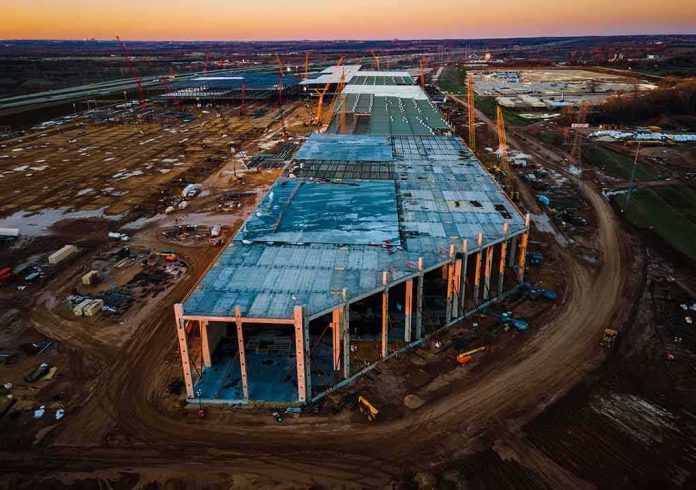 shutterstock_1934238788 aerial view of large industrial building under construction at sunset