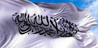 Meloni’s School Crackdown Sparks Europe Shock White flag with black Arabic calligraphy waving in the sky