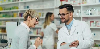 Drug Giants Blink – Medicaid Plays Hardball Pharmacist assists customer at pharmacy counter