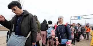 Group of people in winter clothing standing in a line outdoors