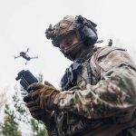 soldier operating a drone with a handheld controller