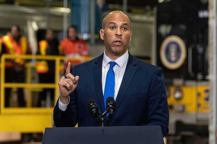 shutterstock_2256331883 Cory Booker speaks at a podium, with Caraun Reid in the background