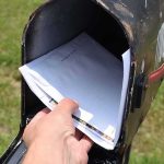 SCOTUS Blocks Trump’s New USPS Ballot Rules Hand retrieving mail from an open rural mailbox