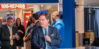 Tucker Carlson at a news desk in a busy studio setting