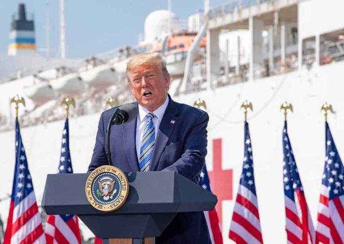 shutterstock_2599911507 Donald Trump speaking at a podium with American flags and a ship in the background