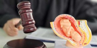 Aborted Baby’s Estate Awarded $200K Judge's gavel beside a fetal model of a pregnant uterus
