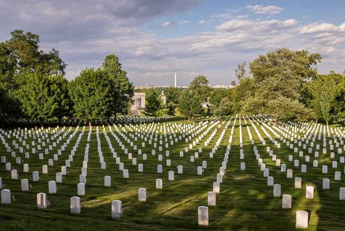 Rows of white headstones in a cemetery under a partly cloudy sky