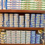 Grocery shelves stacked with assorted canned tuna and seafood