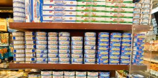 Grocery shelves stacked with assorted canned tuna and seafood