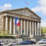 Pope Walks Into a 120 Year French Fight Neoclassical building with columns and French flags