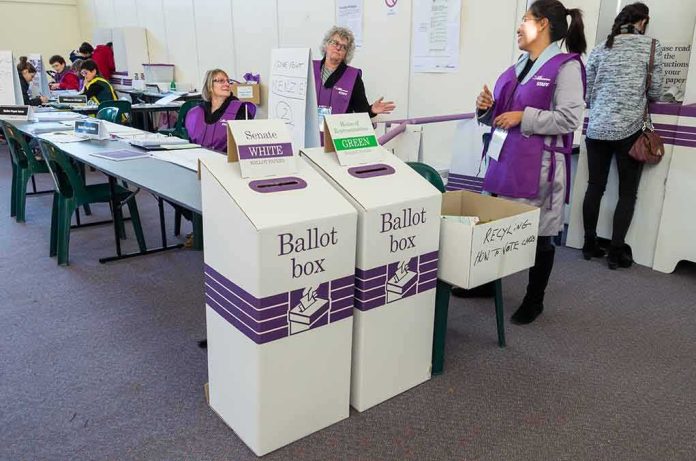 shutterstock_446230945 Dorota Kędzierzawska at a polling place with ballot boxes and election staff