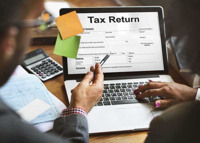 shutterstock_495808516 Laptop displaying tax return form