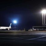 Airliner on a dimly lit airport tarmac at night