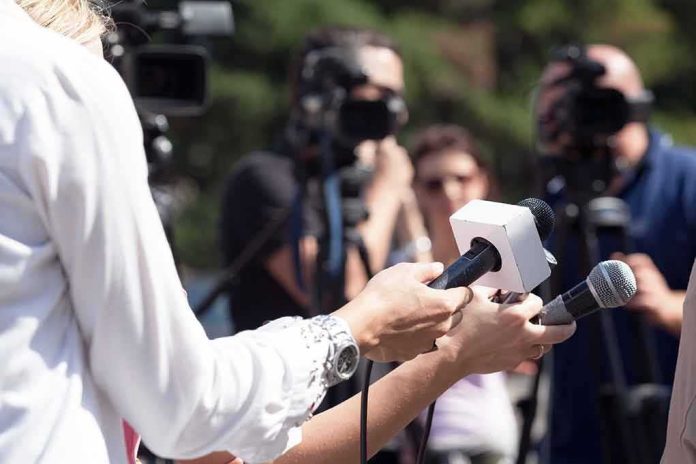 shutterstock_509252728 Reporters hold microphones during an outdoor press interview