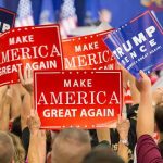 Trump Just Broke A 150-Year Political Tradition Crowd holding red and blue campaign signs at a political rally