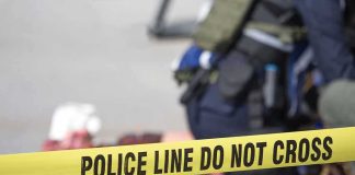 Police tape blocks access at an active scene