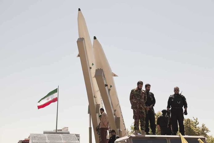 shutterstock_681421708 Soldiers stand beside large missiles at an outdoor display