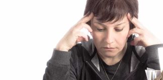 Person stressed while working with paperwork and calculator