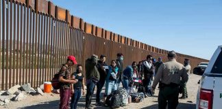Agents’ Union Turns on ‘Border Security’ DEMOCRAT Group of people standing by a border fence with officers and vehicles