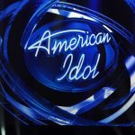 American Idol logo illuminated in blue lights on stage