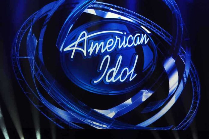 shutterstock_100780810 American Idol logo illuminated in blue lights on stage