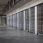 Prison Admissions Could Be Cut in HALF prison cell block with metal barred doors