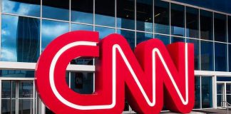 Leftist Streamer SUES Scott Jennings for $72.5M CNN red logo sculpture outside a modern glass building