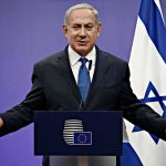 Netanyahu Lands a Major ENDORSEMENT man in suit speaking at a podium with Israeli flag