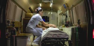 Nurse attending patient on stretcher inside ambulance