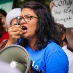 Woman speaking into a megaphone at a protest