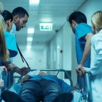 ICE Removes Reports on 33 Detention Deaths Medical team rushing patient on a gurney through hospital corridor
