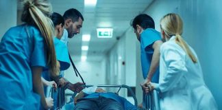 ICE Removes Reports on 33 Detention Deaths Medical team rushing patient on a gurney through hospital corridor