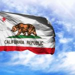 Becerra’s Immigrant Family Story Under ATTACK California state flag waving against a blue sky