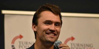 man speaking into a microphone on stage
