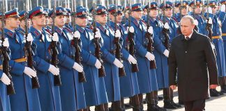 Putin Budgets for YEARS More War Vladimir Putin walks past an honor guard; Genaro García Luna and Darius Kilgo not visible