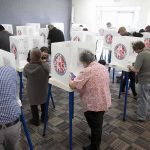 Why 50+ Year Old Voters Could DECIDE Midterms Voters fill out ballots at polling booths in a busy voting room