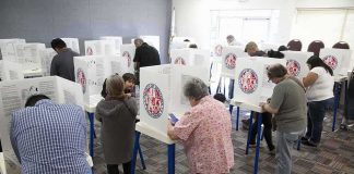 Why 50+ Year Old Voters Could DECIDE Midterms Voters fill out ballots at polling booths in a busy voting room