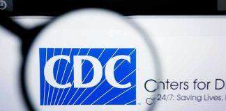 Magnifying glass over CDC logo on a computer screen
