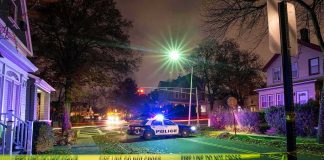 72-Year-Old SHOOTS Off-Duty ICE Agent Police car blocks residential street at night behind caution tape