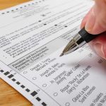 Media IGNORE the 2nd Dan Sullivan Hand holding a pen over a paper election ballot
