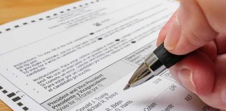 Media IGNORE the 2nd Dan Sullivan Hand holding a pen over a paper election ballot
