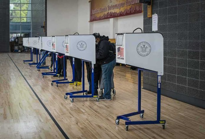 shutterstock_1846768891-1 Voters at polling booths in a gymnasium